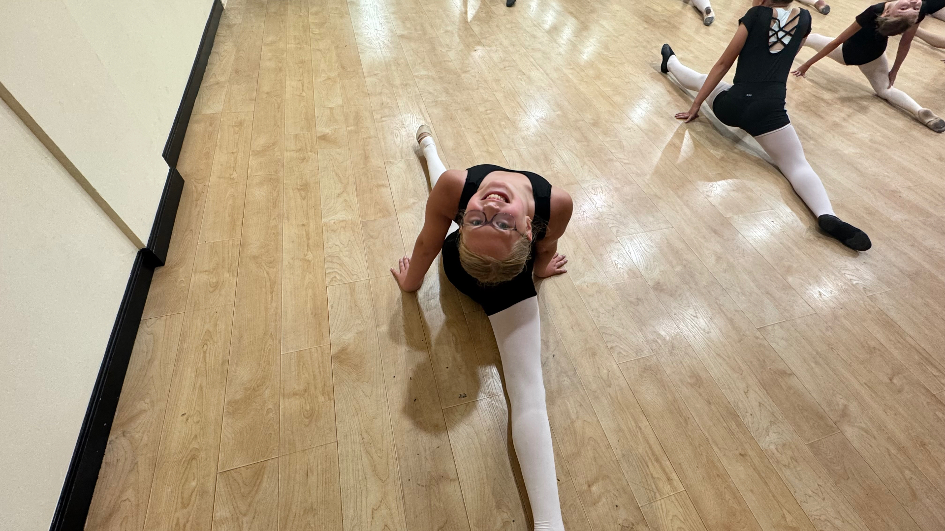 A young dancer stretching into a backbend on the studio floor