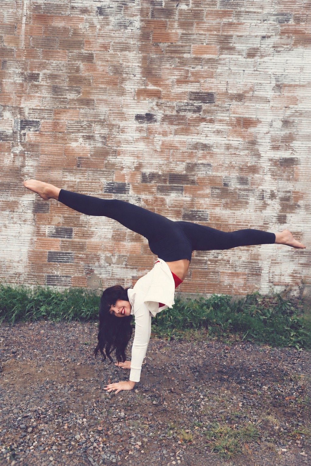 A North Dance Studio dancer in an acro pose in front of a brick wall