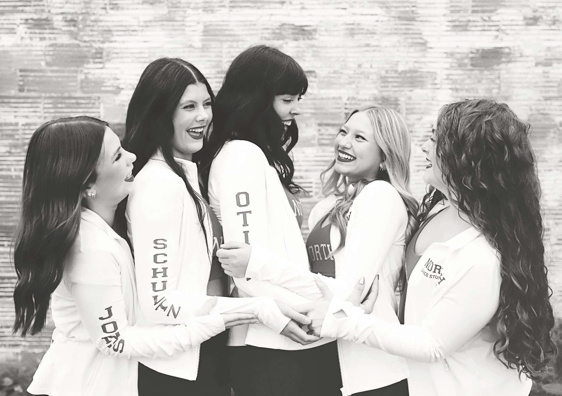 Black and white photo of North Dance Studio instructors laughing together