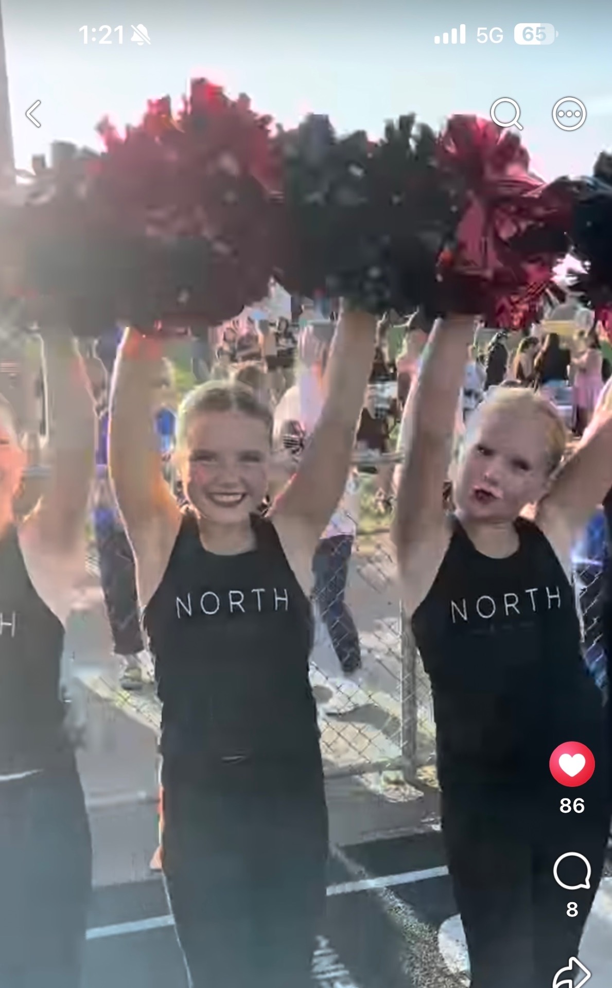 North Dance Studio dancers raising red and black poms during a performance